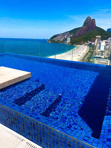a pool with a beautiful ocean view behind