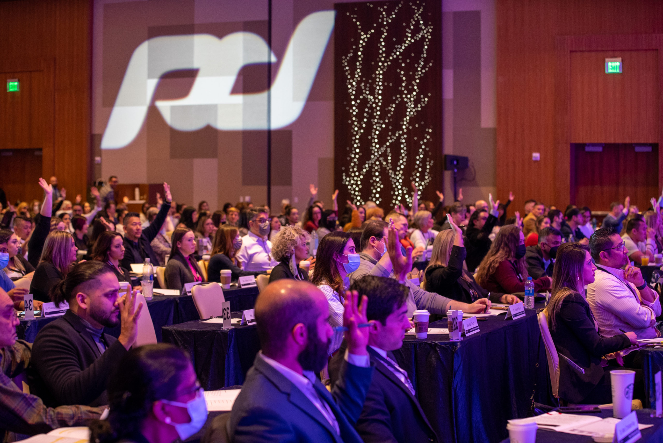 a group of doctors with their hands raised during a TCI boot camp symposium