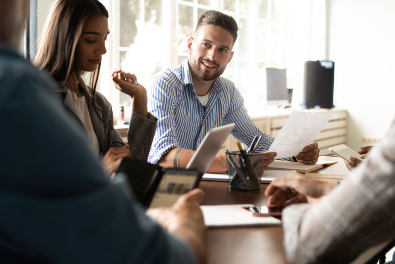 a dental marketing team having a meeting on stock blog content and smilng.