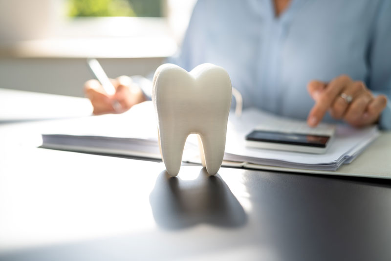 a dentist making financial calculations related to selling a dental practice.