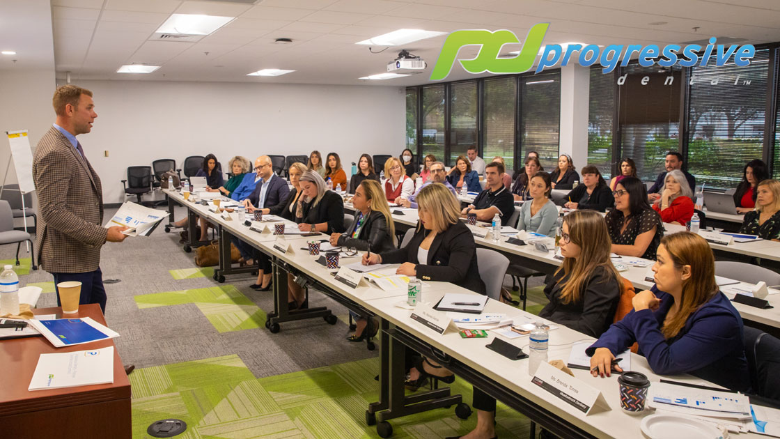 progressive dental hosting a closing institute session in-house|a coaching session at the progressive dental office|a dental professional speaking gently with a smiling patient|a dental professional discussing a dental procedure with a patient|a doctor and a patient rejoicing after a successful dental procedure|a packed room during a closing institute symposium