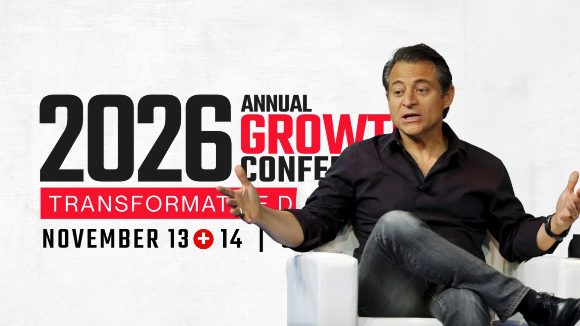 A man in a black button-down shirt sits in a white chair, gesturing as he speaks during an interview. Behind him, graphic text for the 2026 Annual Growth Conference is displayed on a white background.